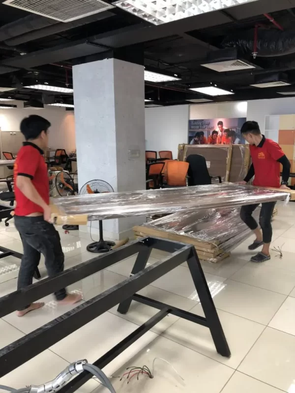 Nhân viên chuyển bàn ghế cồng kềnh