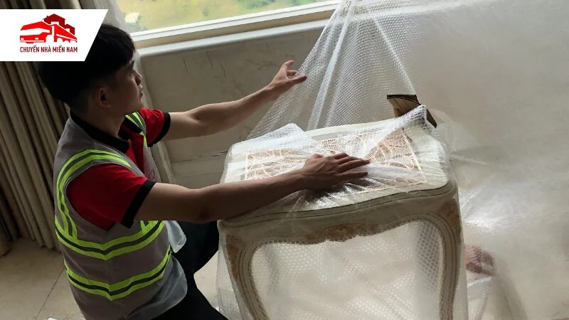 Nhân viên bọc kỹ càng bàn ghế trước khi vận chuyển