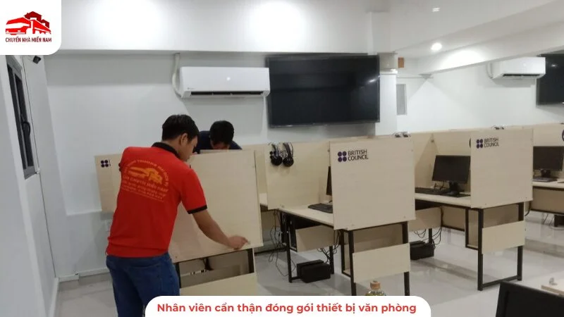 Nhân viên cẩn thận đóng gói thiết bị văn phòng